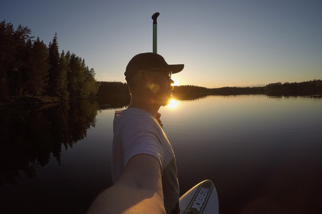 Auringonlasku tyynellä järvellä kesäkuussa 2020