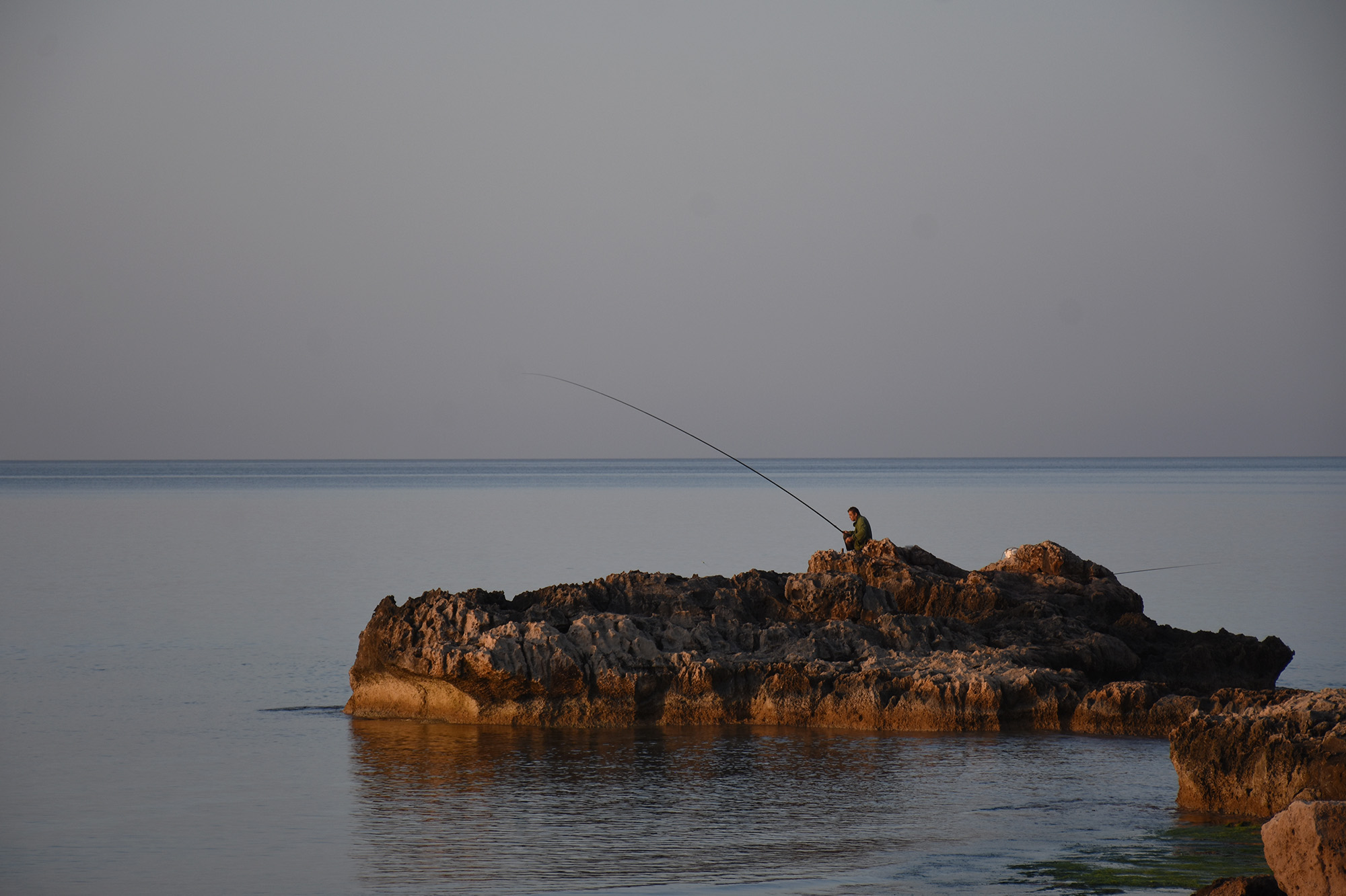Kalastaja aamulla Agia Napan kallioilla